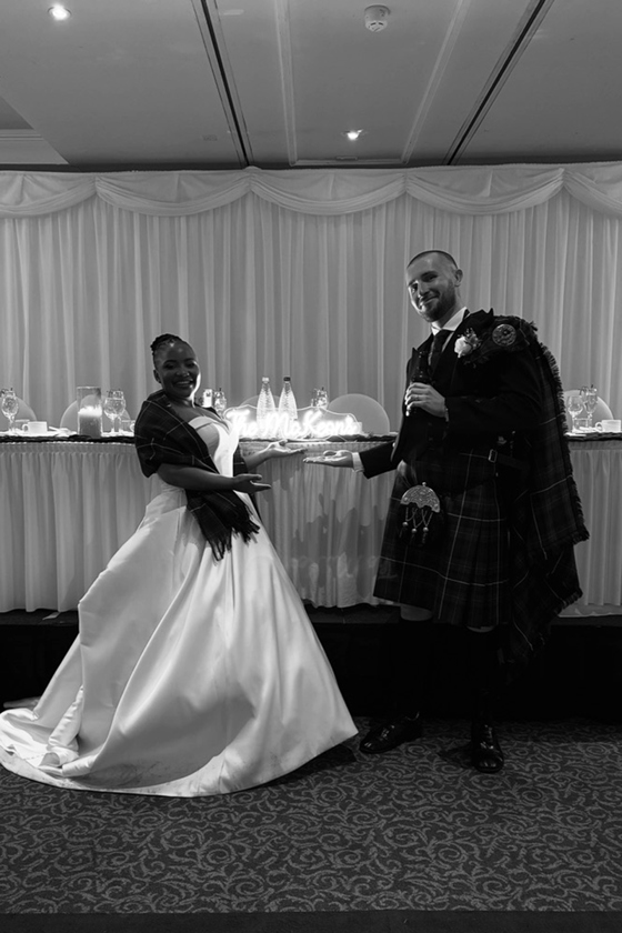 Bride and groom pose next to top table